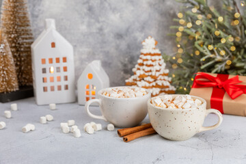 Hot drink with marshmallows and candy cane in cup on texture table.Cozy seasonal holidays.Hot cocoa with gingerbread Christmas cookies.Hot chocolate with marshmallow and spices.Copy space.