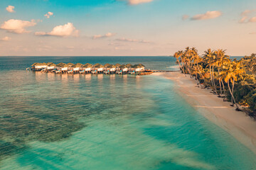 Amazing aerial beach landscape. Beautiful Maldives sunset seascape view. Horizon colorful sea sky clouds over water villa pier pathway. Tranquil drone view island lagoon tourism travel exotic vacation - obrazy, fototapety, plakaty