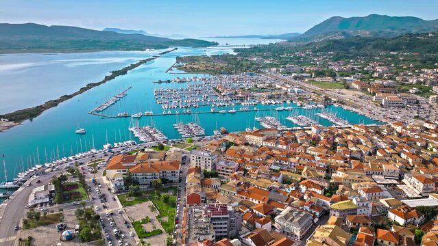 Aerial view of D-Marin Lefkas Marina full of boats and ships in Lefkada. The island's capital and port town with turquoise waters, Greek-style houses with colourful shutters, and wooden balconies.