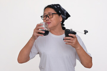 An Asian woman wearing a headband and white t-shirt is enjoying the aromatic smell of coffee beans