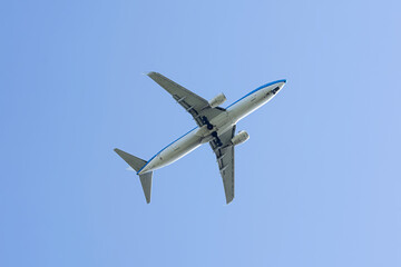 Twin engine passenger plane high in blue sky view from below