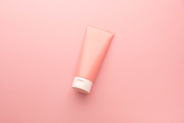 Blank pink squeeze bottle plastic tube on pink background. Packaging of cream, lotion, gel, facial foam skincare. Cosmetic beauty product branding.