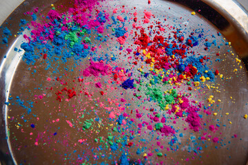 Multicolored Holi paints poured on a metal tray. Color background for the Indian national holiday...