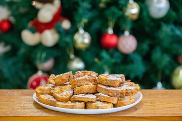Typical Brazilian Christmas Rabanadas with egg yolk cream and cinnamon, Spanish Torrijas on golden plate on a Christmas dinner table. Fine details