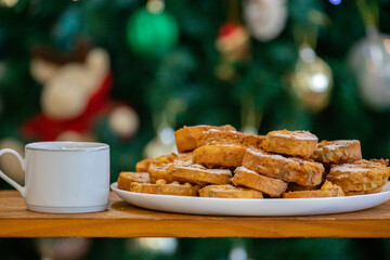 Typical Brazilian Christmas Rabanadas with egg yolk cream and cinnamon, Spanish Torrijas on golden plate on a Christmas dinner table. Fine details