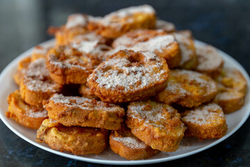 Typical Brazilian Christmas Rabanadas with egg yolk cream and cinnamon, Spanish Torrijas on golden plate on a Christmas dinner table. Fine details