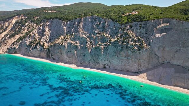 Porto Katsiki beach with turquoise water bordered by concave pale cliffs. Aerial view of crystal clear blue waters with picturesque views on the Ionian island of Lefkada, Greece.