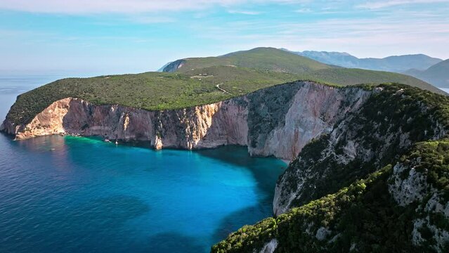 Aerial view of Lefkada rocky cliffs, blue lagoon. Historical lighthouse, and turquoise waters by coastline.