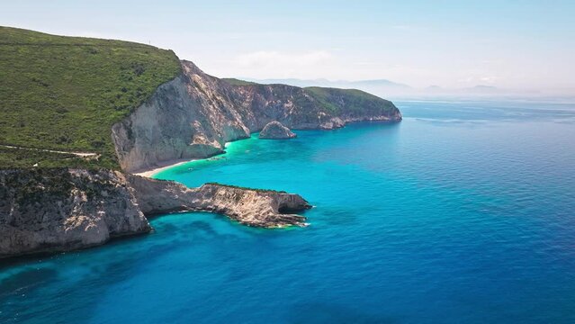 Porto Katsiki beach with turquoise water bordered by concave pale cliffs. Aerial view of crystal clear blue waters with picturesque views on the Ionian island of Lefkada, Greece.