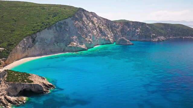 Porto Katsiki beach with turquoise water bordered by concave pale cliffs. Aerial view of crystal clear blue waters with picturesque views on the Ionian island of Lefkada, Greece.
