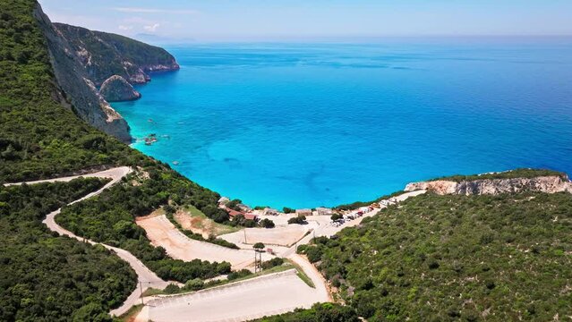 Porto Katsiki beach with turquoise water bordered by concave pale cliffs. Aerial view of crystal clear blue waters with picturesque views on the Ionian island of Lefkada, Greece.