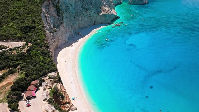 Porto Katsiki beach with turquoise water bordered by concave pale cliffs. Aerial view of crystal clear blue waters with picturesque views on the Ionian island of Lefkada, Greece.