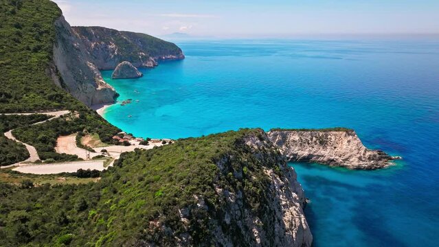 Porto Katsiki beach with turquoise water bordered by concave pale cliffs. Aerial view of crystal clear blue waters with picturesque views on the Ionian island of Lefkada, Greece.