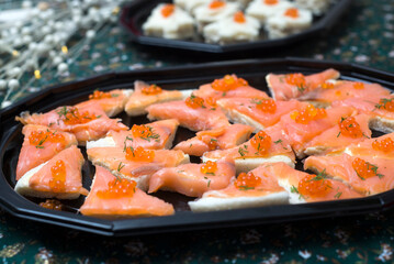 Closeup of appetizers toast with salmon and lumpfish roe in a black plate lumpfish roe