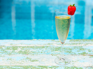 Champagne glass with strawberry on turquiose background