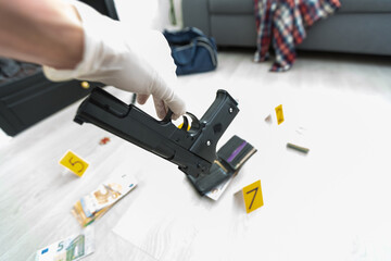 Close up on hands of unknown man forensic police investigator collecting evidence in the plastic bag at the crime scene investigation