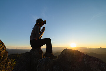 Silhouette of The girl  prayed  in the mountains to think of a loving God, we praise God.