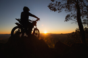 Man with motocross bike against beautiful lights, silhouette of a man with  motocross motorcycle On...