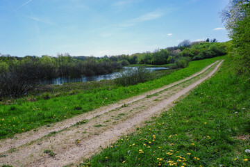 Fototapeta premium View of dirt road in countryside near the pond.