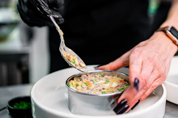 Professional chef cooking Salad Olivier in restaurant kitchen