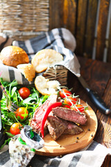 Sliced medium rare grilled Beef steak Ribeye on cutting board on wooden background