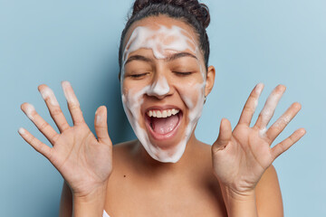 Facial skin care routine and hygiene concept. Overjoyed Latin woman keeps palms raised up exclaims...