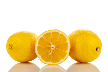 One half and two whole yellow juicy lemons, close-up, isolated on white.