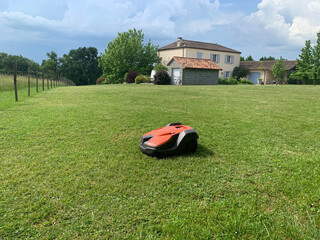 Robotic lawn mower on grass, side view - obrazy, fototapety, plakaty