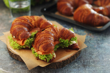 Freshly baked croissants with salmon and salad on the table