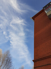Brick building against a background of blue sky with clouds.