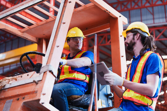 Teamwork working driver at warehouse forklift loader works to containers box in commercial transport port, Transport and container team. warehouse factory worker male control forklift.