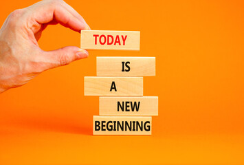 Today is a new beginning symbol. Concept words Today is a new beginning on wooden blocks. Beautiful orange background. Businessman hand. Business today is a new beginning concept. Copy space.