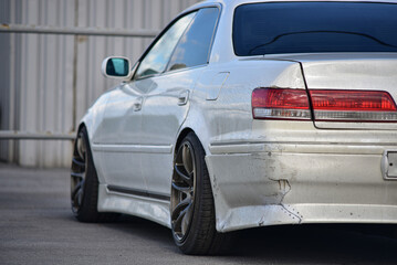 A white car is parked in the parking lot. Back view.