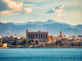 Palma, Majorca, Spain - View of Mallorca Cathedral from a ship in the harbour, against a mountain backdrop. - obrazy, fototapety, plakaty