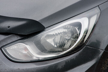 Halogen headlight on a gray car. Close-up.