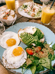 Breakfast with eggs, avocado, juice, greens
