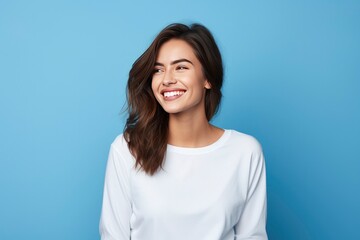 Photo of attractive brunette young woman wearing casual clothes standing isolated over blue background - obrazy, fototapety, plakaty