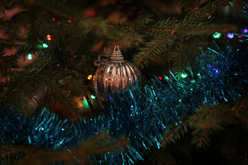 New Year's toys on the branches of a green Christmas tree.