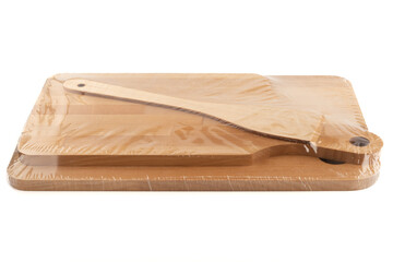 Polyethylene-wrapped kitchen wooden set of cutting boards and kitchen spatula.