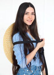 Beautiful woman in straw hat and blue shirt looking at camera