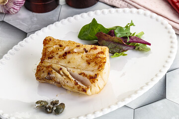 Roasted cod fish steak with salad