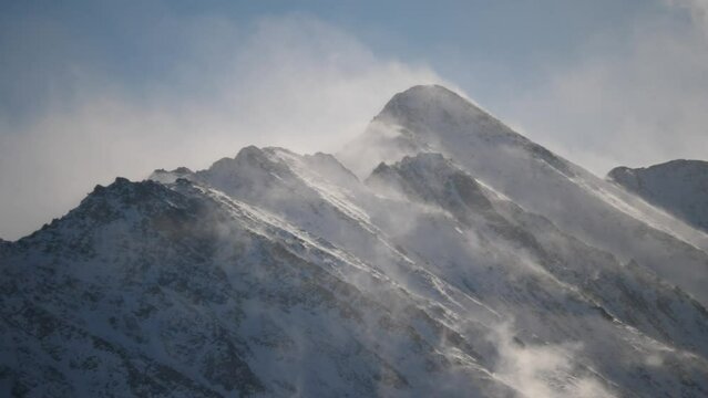 snowed mountain peaks, with wind and dust