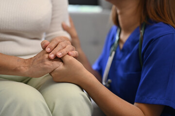Cropped shot of caring nurse holding senior woman hands for hope and supporting. Elderly healthcare...