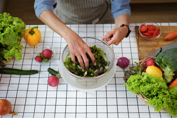 Above view of senior man making fresh salad on kitchen table organic vegetables.