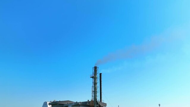 An industrial facility releasing thick black emissions, portraying air pollution's dire consequences. Sulfur dioxide and Nitrogen oxides concept. Bird's eye view by drone. Stock footage. 4K.
