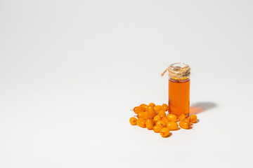A bottle of sea buckthorn oil and sea buckthorn berries on a white background
