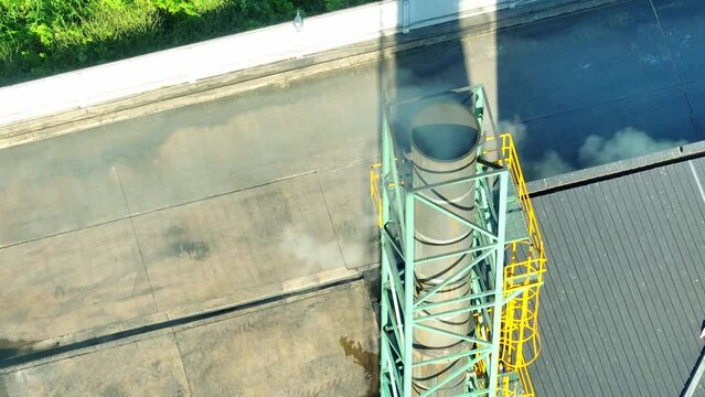 The industrial plant exhales smoky tendrils, a somber dance of pollution, staining the heavens with its remorseless embrace of nature's demise. Environmental impact and carbon dioxide concept. Drone.

