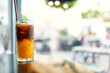 Coffee tonic with piece of orange and ice in glass