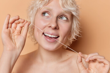Oral hygiene and dental care concept. Fair haired woman showcases radiant smile while holding...