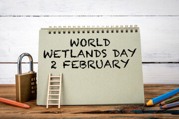 World Wetlands Day .Green notepad on wooden texture table and white background